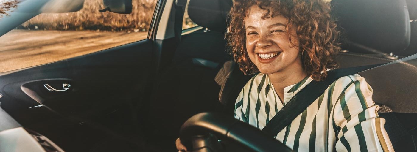 Young woman driving a car, smiling