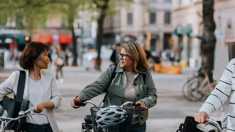 Women walking together with bicycles
