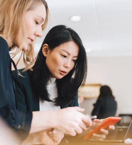 Colleagues use mobile phones during conferences in offices