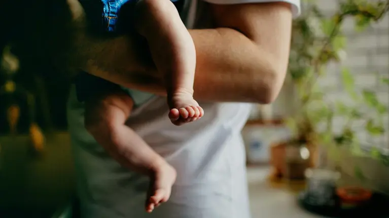 A close-up of a father holding his baby