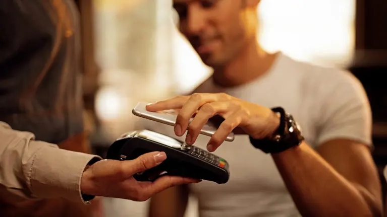 Close up of guest using smart phone while making contactless payment in a pub. ; Shutterstock ID 1384574945; purchase_order: N/A; job: TE-B; client: Tietoevry; other: