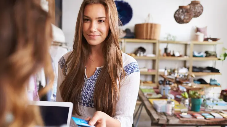 Teenage young woman paying with credit card in a boutique