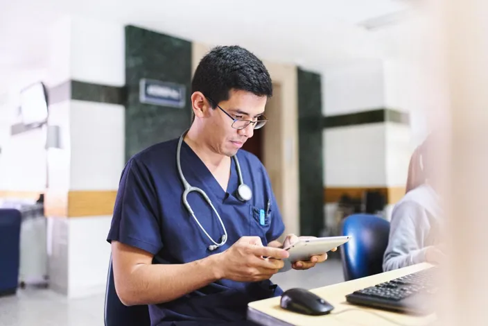 Young medical doctor is using an ipad tablet doing administration and medical healthcare reports