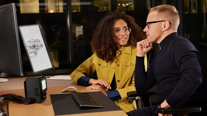 Man and woman working in office on computer designing