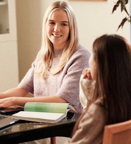 Two girls studying at table in livingroom