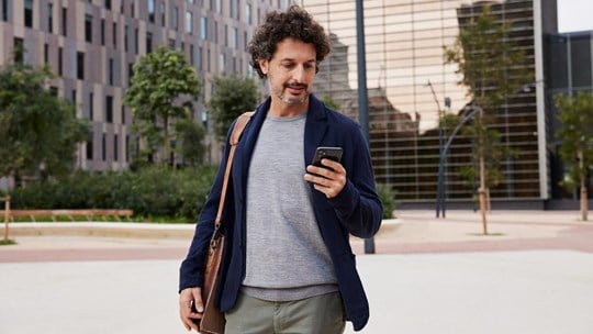 Man walking in the street using mobile phone