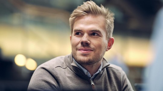 Man sitting inside office, smiling